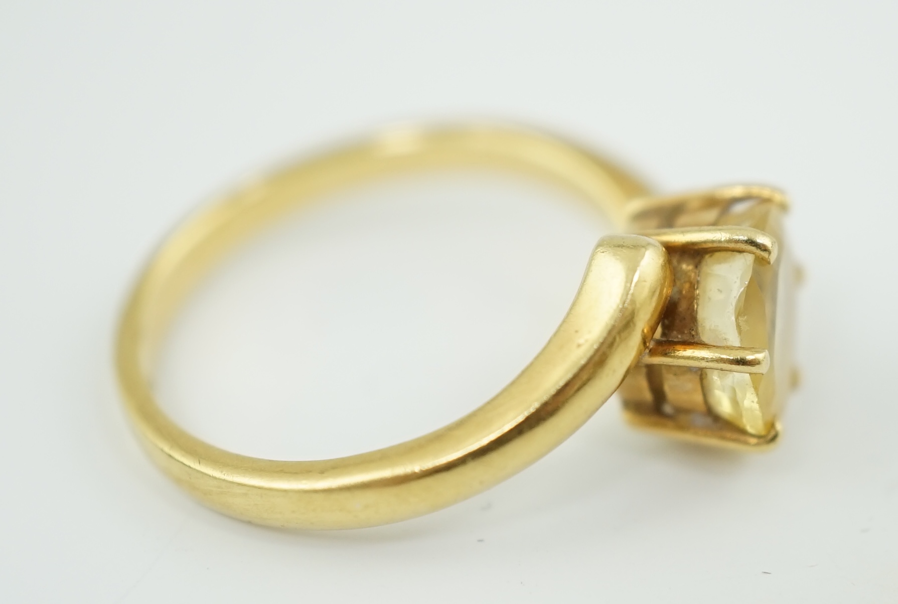 An 18k gold and solitaire oval cut yellow sapphire